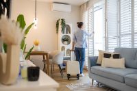 © pikselstock - stock.adobe.com Foto: Frau öffnet Fenster in Wohnung