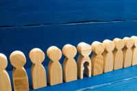 © Andrii Yalanskyi - stock.adobe.com Foto: Holzfiguren in einer Reihe, eine hat ein ausgeschnittenes Kind