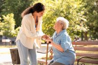 © Pixel-Shot - stock.adobe.com Foto: Alte Dame auf Bank und Pflegerin