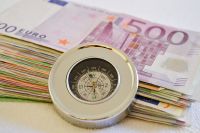 © Martina Wendt - stock.adobe.com Foto: Geldscheine mit eine Kompass davor